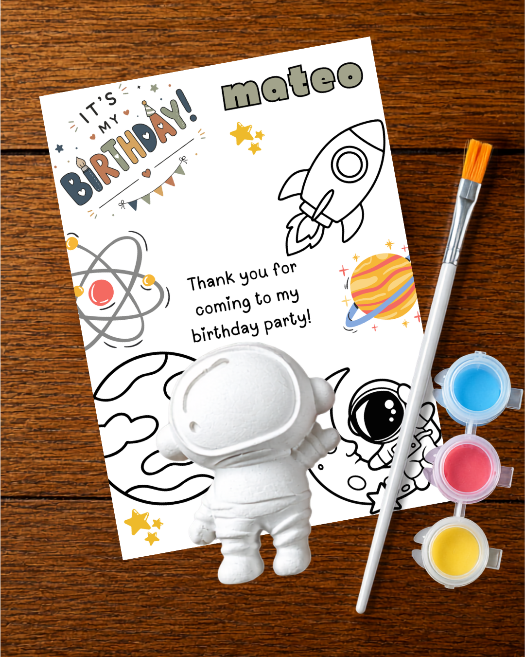 Personalized JAME Studio birthday party favor with an astronaut plaster figurine, printed card, paints and brush